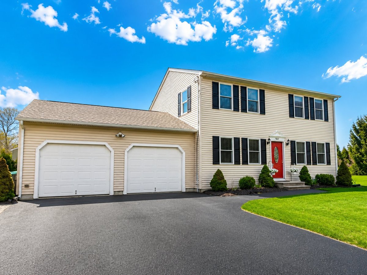 The Waypoint — colonial home with red front door, two-car garage, green lawn